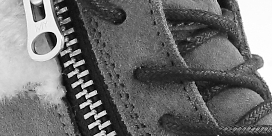 Close detail of a zip and laced panel on a suede sheepskin boot